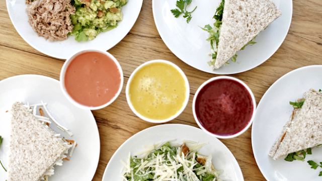 Uma mesa com sanduíches e molhos.