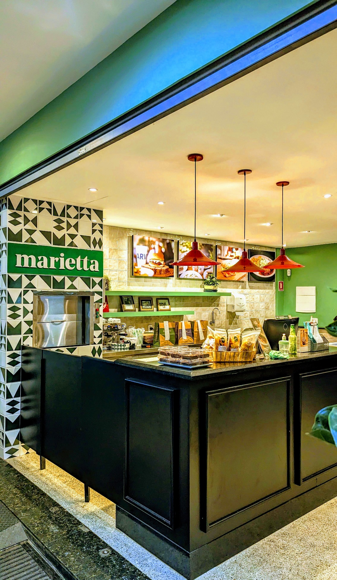 Fachada de uma loja Marietta em Brasília com o logo verde e balcão de atendimento